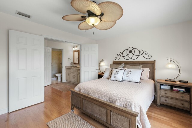 bedroom with connected bathroom, light hardwood / wood-style floors, and ceiling fan