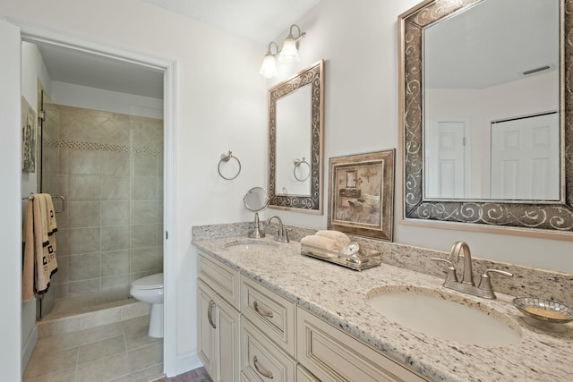 bathroom with tile patterned floors, vanity, toilet, and walk in shower