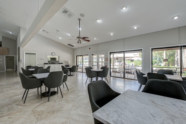 dining space featuring ceiling fan, beam ceiling, and high vaulted ceiling