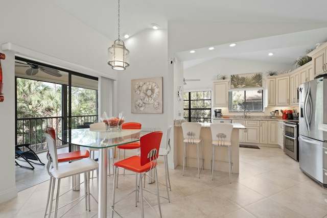 dining room with ceiling fan, a healthy amount of sunlight, sink, and high vaulted ceiling