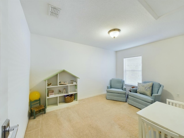 living area with light colored carpet and a textured ceiling