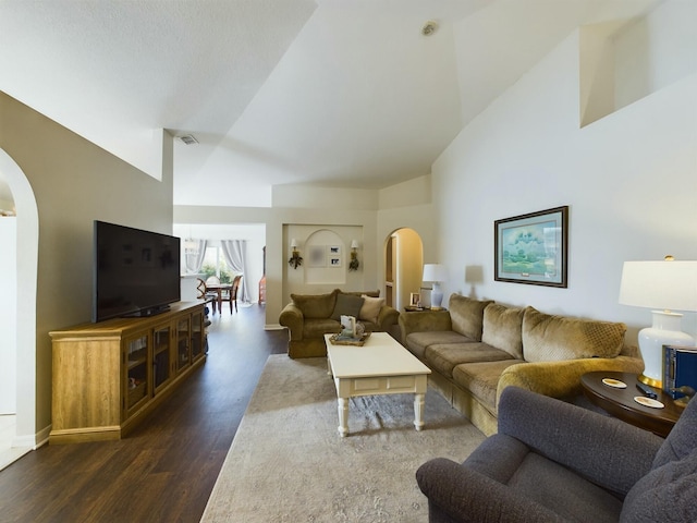 living room with dark hardwood / wood-style flooring and high vaulted ceiling