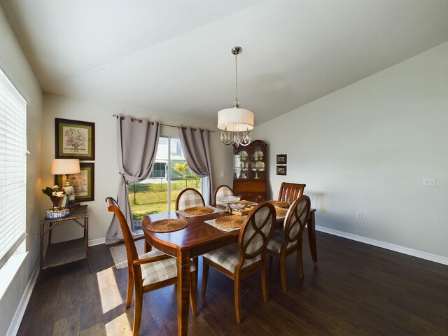 dining space featuring lofted ceiling, a chandelier, and dark hardwood / wood-style floors