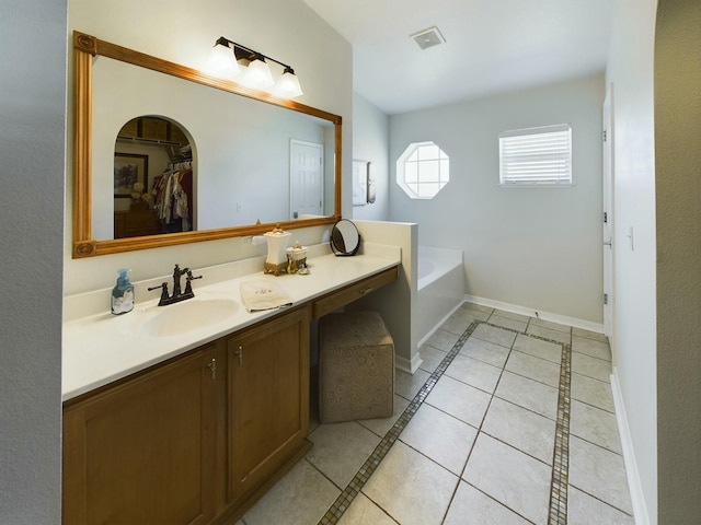 bathroom with tile patterned flooring, a bath, and vanity