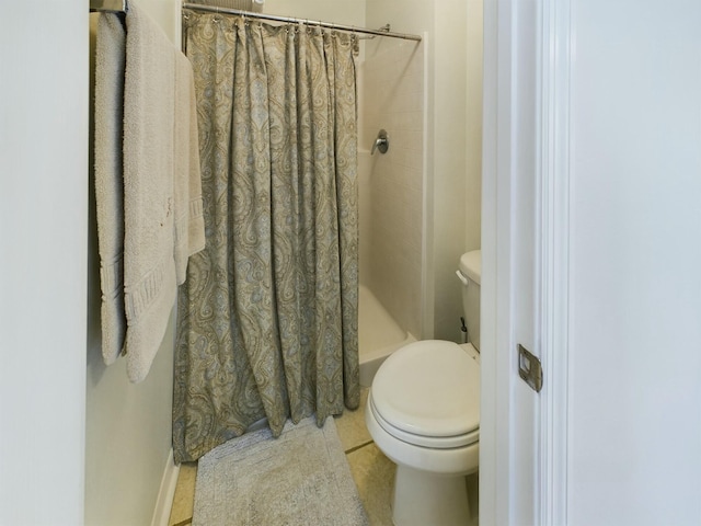 bathroom featuring tile patterned flooring, curtained shower, and toilet