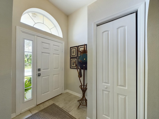 entryway with a healthy amount of sunlight and light tile patterned flooring