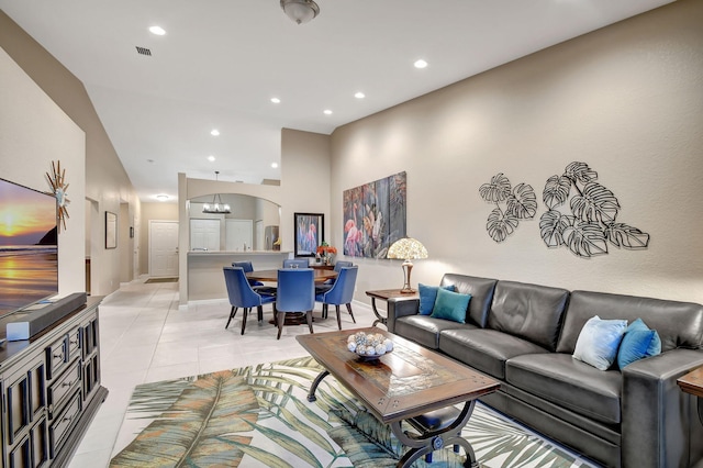 tiled living room featuring an inviting chandelier