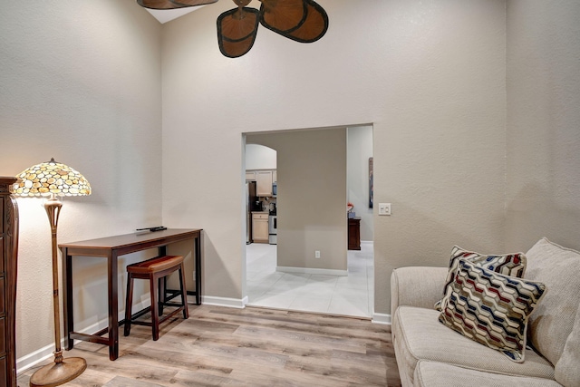 9383 Bridgeport Dr, West Palm Beach, FL 33411 - living area featuring ceiling fan, light wood-style floors, baseboards, and arched walkways