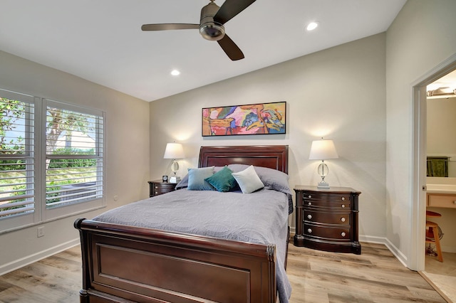 bedroom with ceiling fan, ensuite bathroom, light hardwood / wood-style floors, and vaulted ceiling