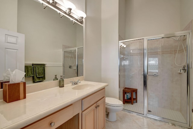 bathroom featuring tile patterned floors, vanity, toilet, and a shower with door