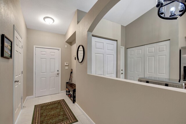 9383 Bridgeport Dr, West Palm Beach, FL 33411 - doorway featuring light tile patterned floors, arched walkways, baseboards, and a chandelier