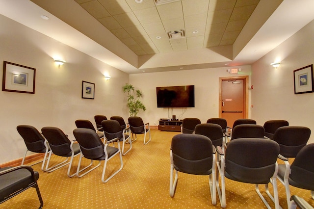 carpeted home theater with a tray ceiling