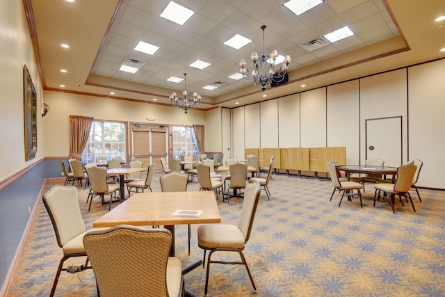 carpeted dining room featuring a tray ceiling, ornamental molding, a chandelier, and a towering ceiling