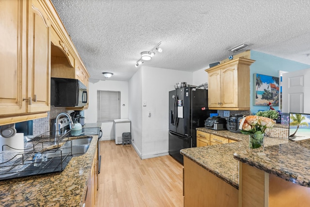 kitchen with decorative backsplash, light brown cabinets, light hardwood / wood-style floors, and black appliances