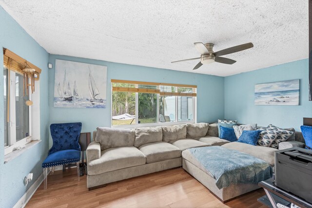 living room featuring hardwood / wood-style floors, a textured ceiling, and ceiling fan