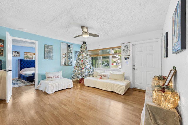 bedroom with a textured ceiling, hardwood / wood-style flooring, and ceiling fan