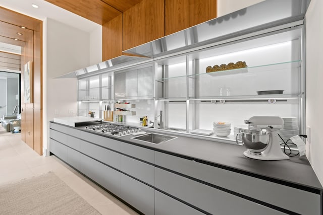 kitchen featuring light tile patterned floors, stainless steel gas cooktop, light countertops, open shelves, and modern cabinets