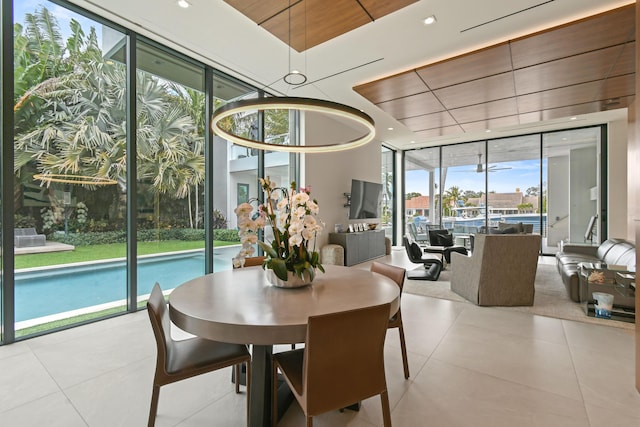 dining room with light tile patterned floors, a wall of windows, and recessed lighting