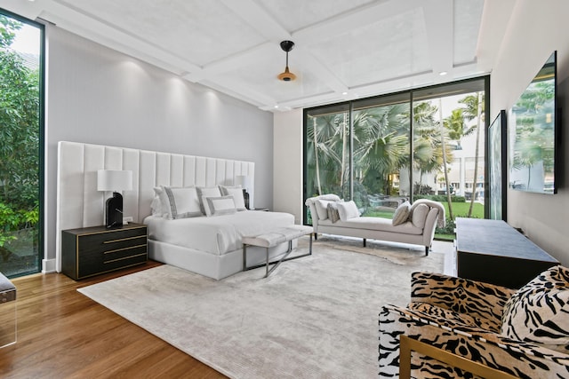 bedroom featuring expansive windows, wood finished floors, and multiple windows