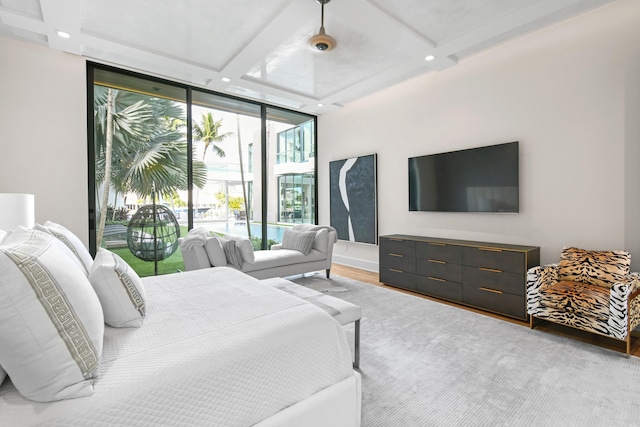 bedroom featuring light wood-style flooring, beamed ceiling, access to exterior, expansive windows, and recessed lighting