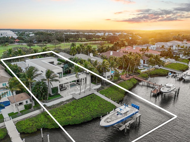 aerial view at dusk featuring a water view