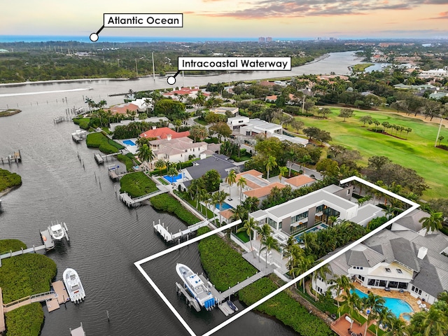 aerial view at dusk with a residential view and a water view