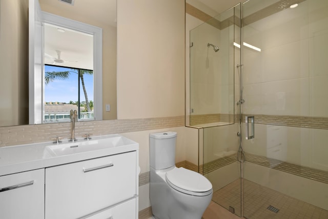 bathroom featuring toilet, visible vents, vanity, tile walls, and a shower stall