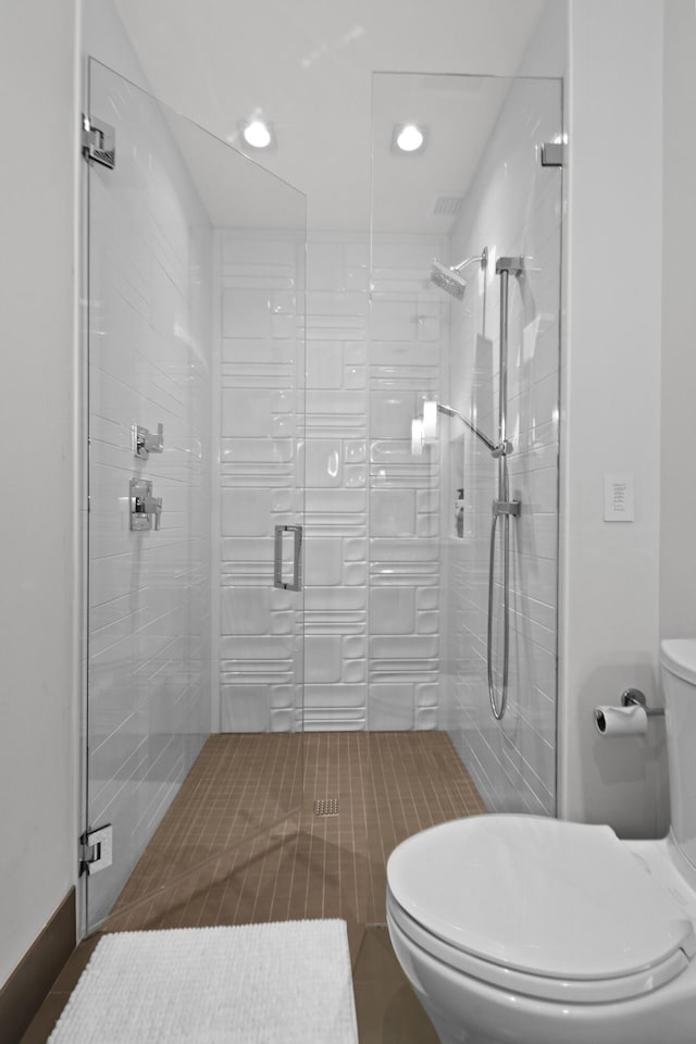 bathroom with toilet, a shower stall, and recessed lighting