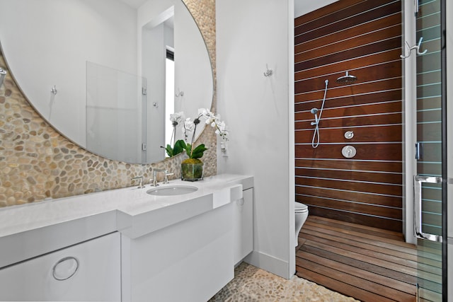 bathroom featuring toilet, vanity, and decorative backsplash