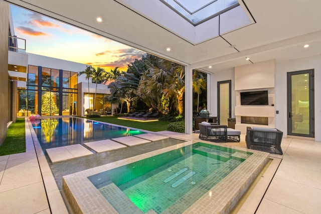 pool featuring a patio and an in ground hot tub