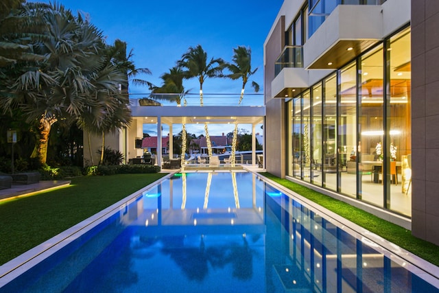 pool at dusk with a lawn