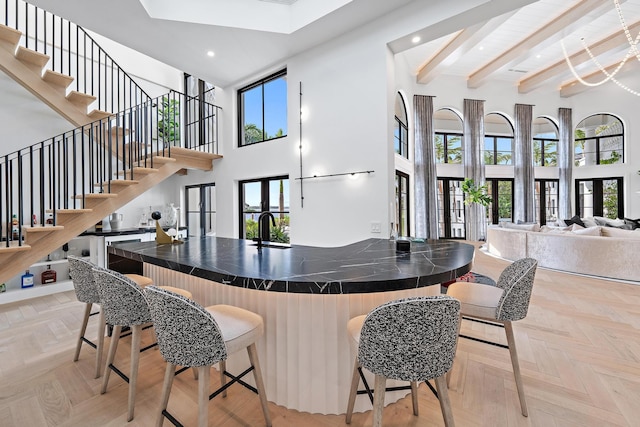 bar featuring french doors, plenty of natural light, light parquet floors, and a high ceiling