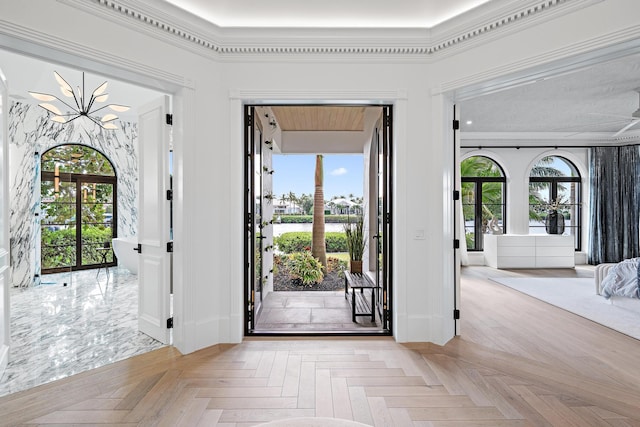 entryway with light parquet flooring, a wealth of natural light, and crown molding