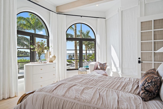 bedroom featuring light hardwood / wood-style flooring and beamed ceiling