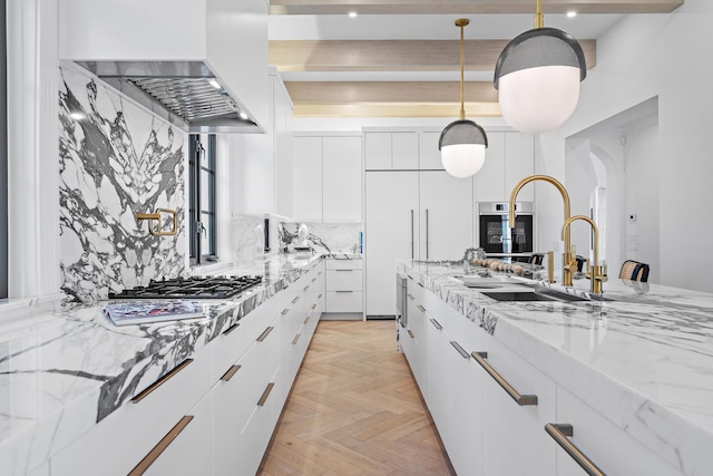 kitchen featuring white cabinetry, light parquet floors, pendant lighting, and wall chimney range hood