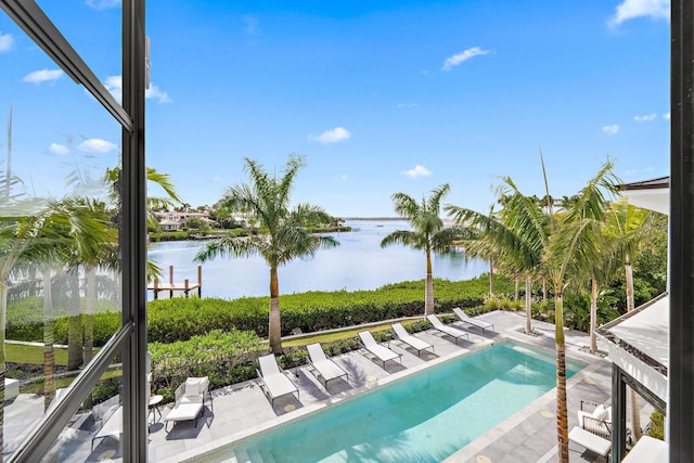 view of swimming pool featuring a patio and a water view