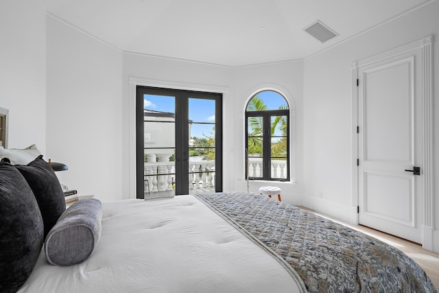 bedroom with access to outside, multiple windows, french doors, and light hardwood / wood-style floors