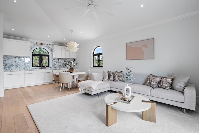 living room with ceiling fan, light hardwood / wood-style flooring, sink, and ornamental molding