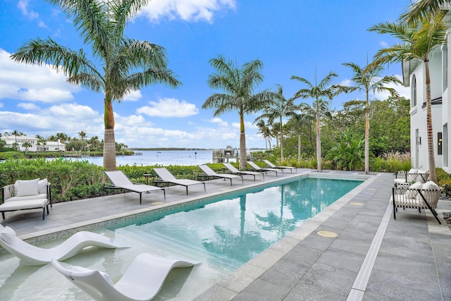 view of pool featuring a patio area and a water view