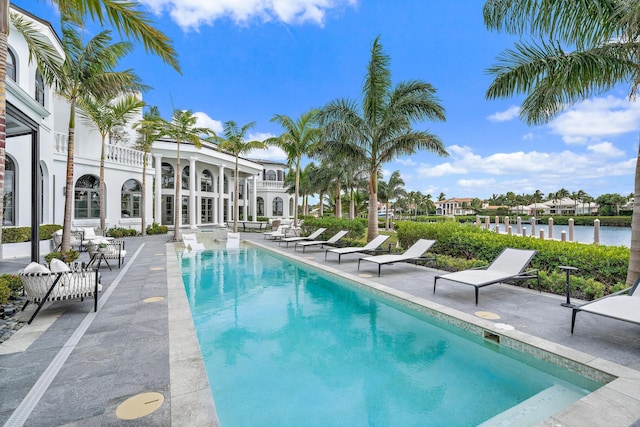 view of pool with a patio area and a water view