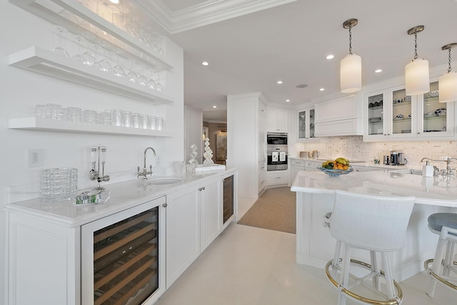 bar featuring sink, beverage cooler, decorative light fixtures, white cabinets, and ornamental molding