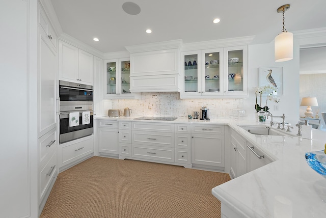 kitchen featuring sink, crown molding, decorative light fixtures, light carpet, and white cabinets