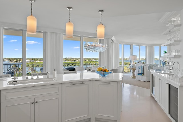 kitchen featuring sink, white cabinets, and pendant lighting