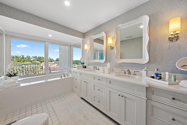 bathroom featuring a bathing tub, tile patterned flooring, and vanity