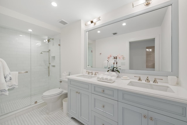 bathroom with vanity, toilet, and a shower with door