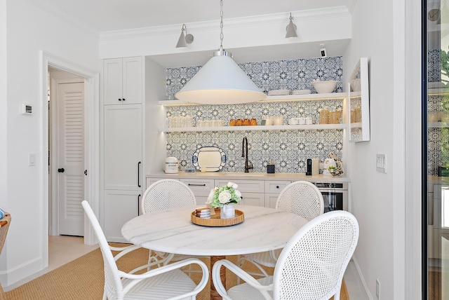 dining area with sink and crown molding