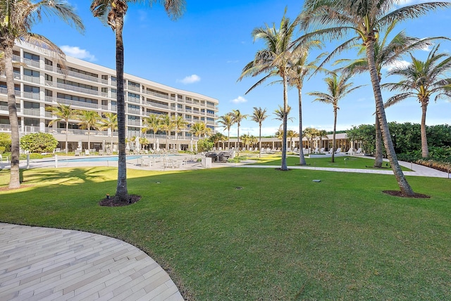 view of property's community with a lawn and a swimming pool