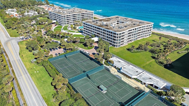 birds eye view of property with a water view and a beach view