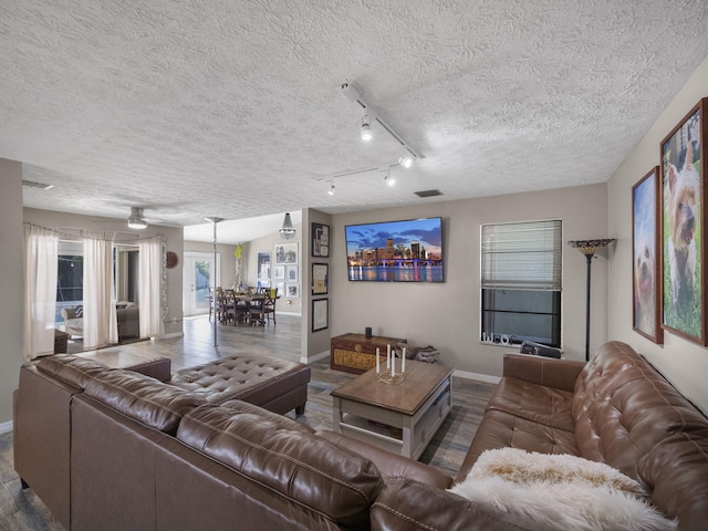 living room with hardwood / wood-style flooring, ceiling fan, a textured ceiling, and track lighting