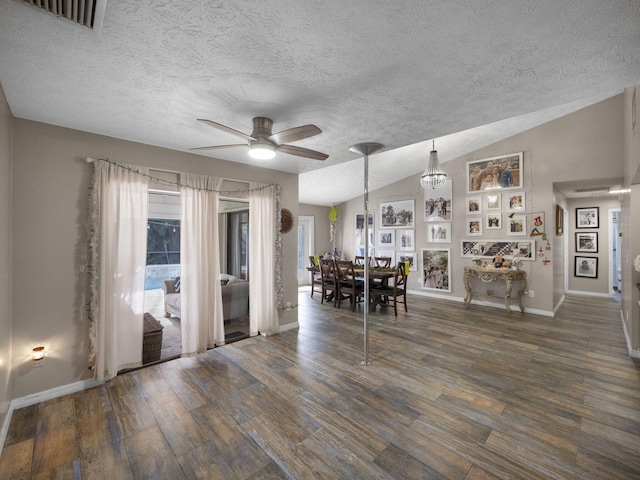 unfurnished dining area with a textured ceiling, dark hardwood / wood-style floors, vaulted ceiling, and ceiling fan